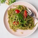 Espaguetis con pesto de rúcula y tomates